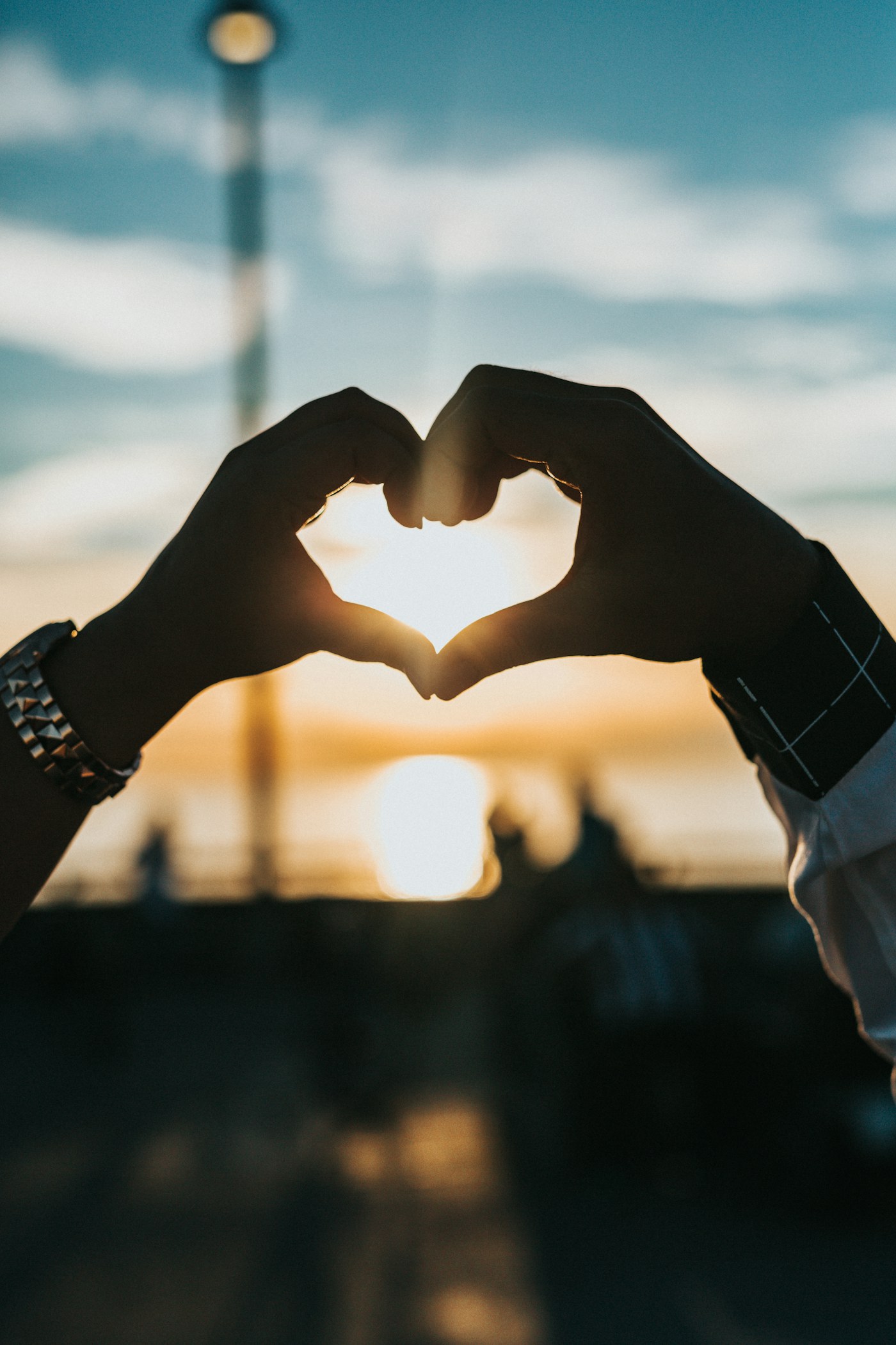 Two hands forming a heart in the evening light